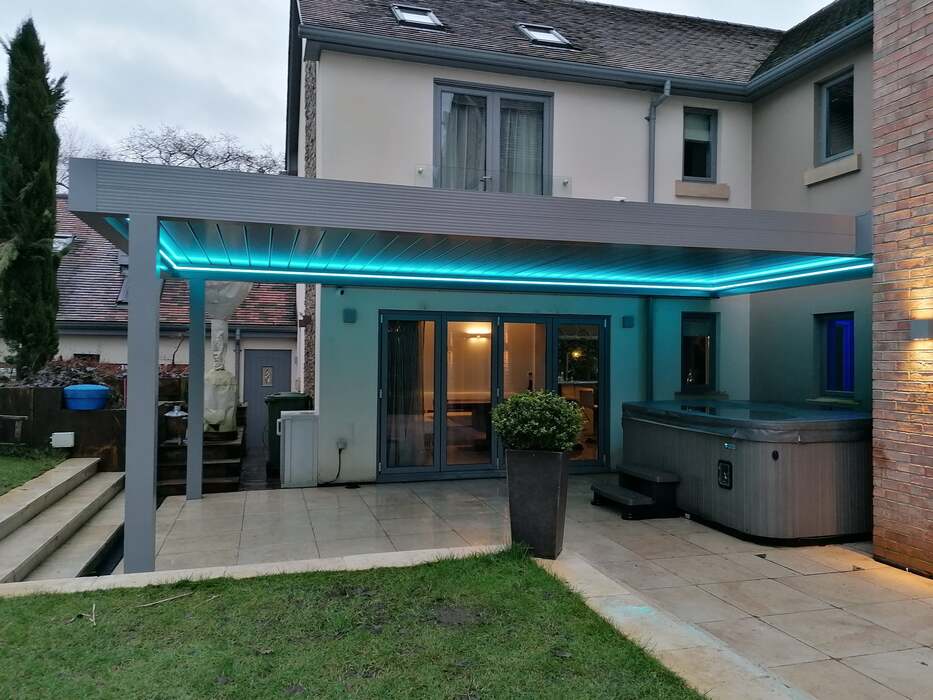 Solid looking Bespoke Aluminium Pergola with LED Lighting against a building - covering a Hot Tub