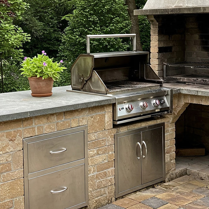 Outdoor brick kitchen with grill and chimney.