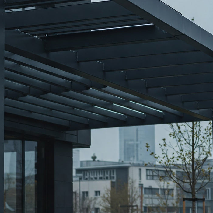 A modern gray metal pergola outside a building.