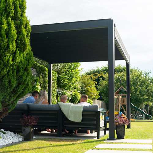 Nova Titan within a family garden, family sitting on furniture underneath pergola. Climbing frame and mature bushes in background
