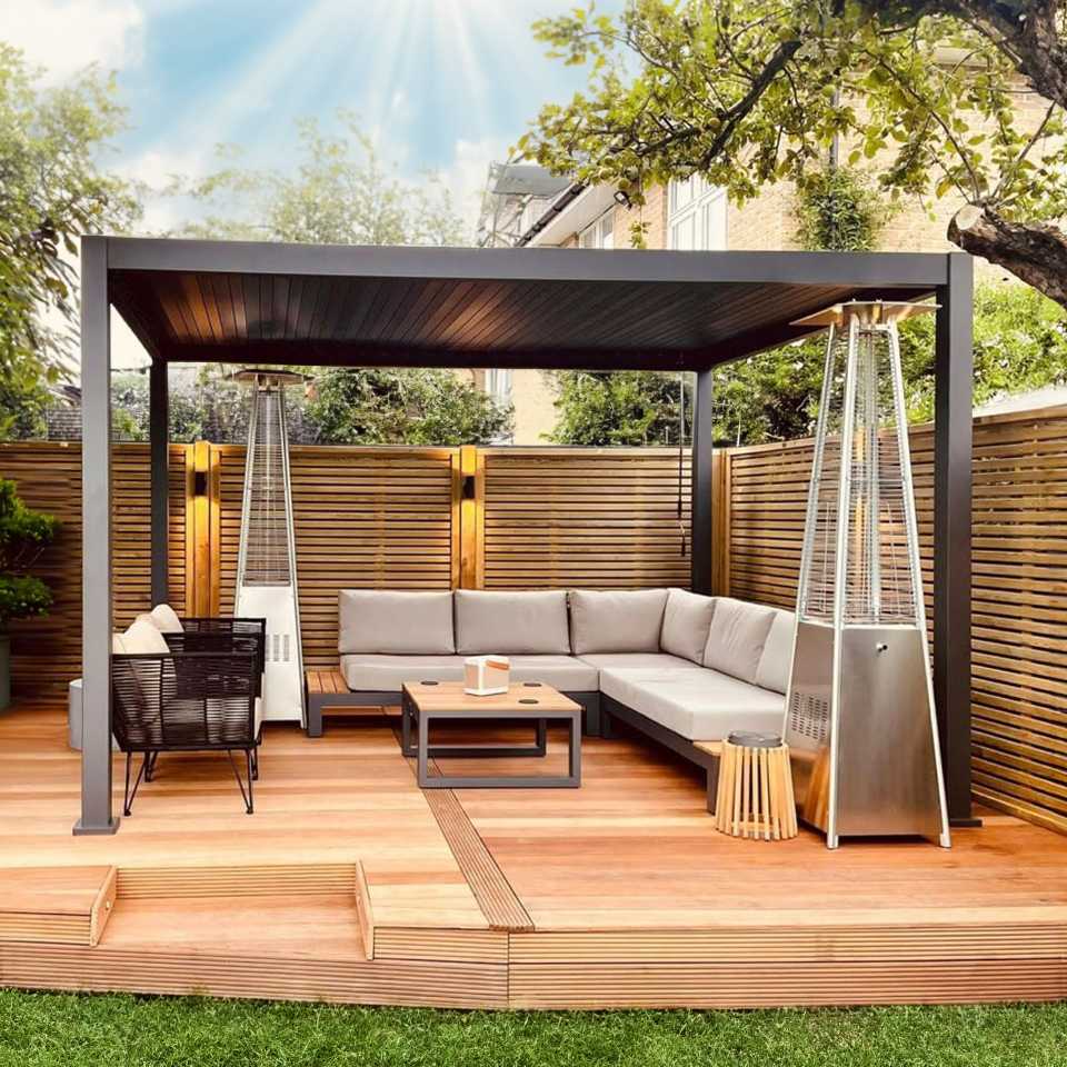 Nova Titan Grey Aluminium Pergola on a raised decking area with modern furniture underneath and panelled fencing all around