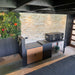 Outdoor patio area with a stone wall, potted plants, and outdoor kitchen storage