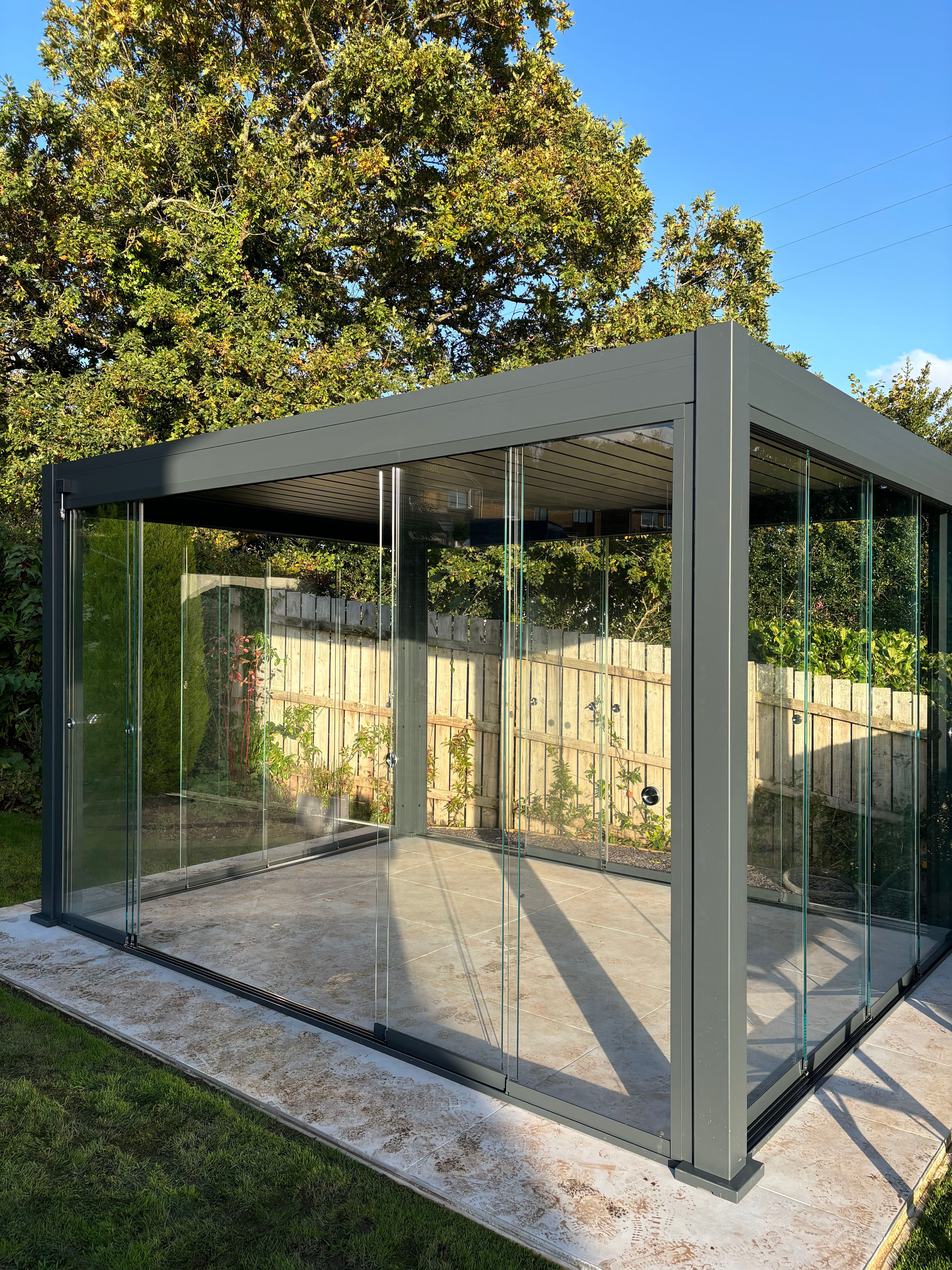Grey pergola with glass sliding doors on each side