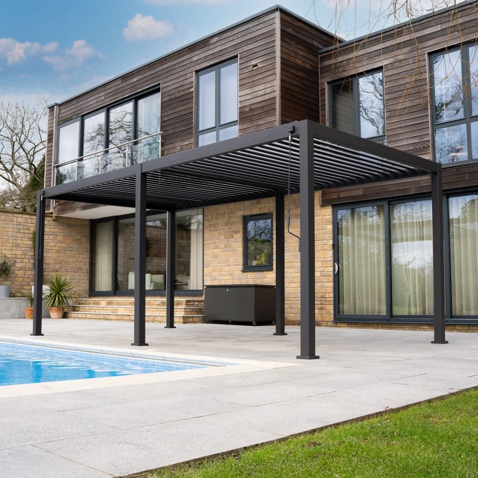 Nova Titan 5.3x3m aluminium pergola in grey installed on a patio in a landscaped UK garden